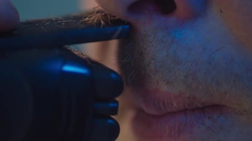 Man Trimming Facial Hair with Electric Razor