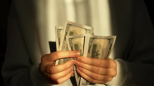 Hands Counting Stack of US Hundred Dollar Bills