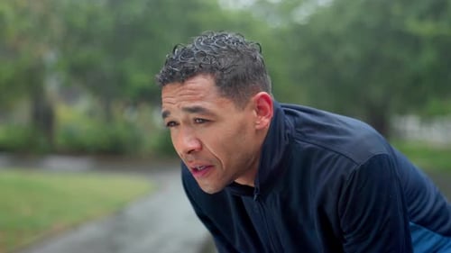 Breathe, fitness and man in park tired for marathon training, exercise and cardio workout