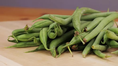 A Pile of Fresh Green Beans a Staple Food Ingredient Rests on a Wooden Cutting Board These Natural
