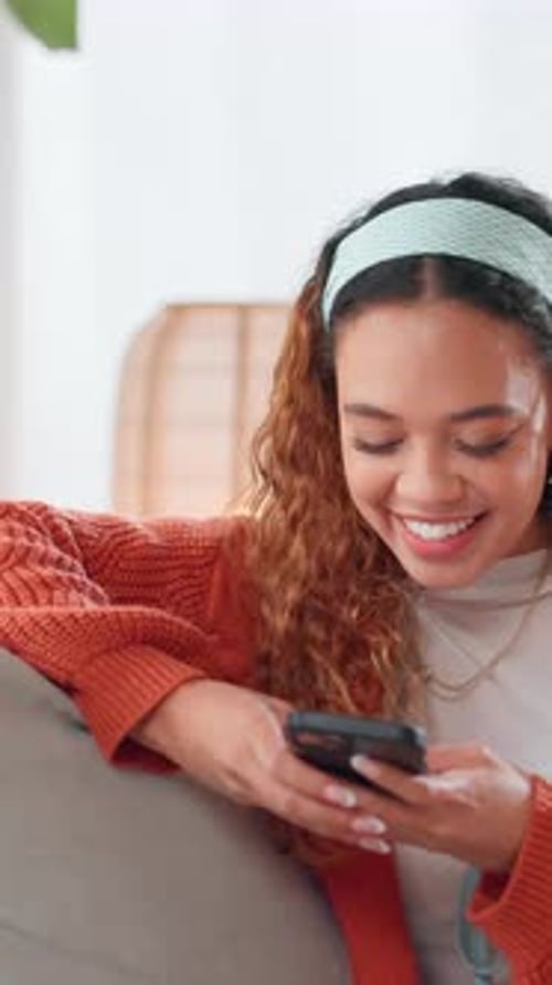 Smiling Woman Relaxing at Home with Phone