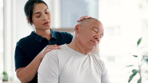 Senior Man Receives Neck Massage from Young Adult
