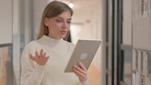 Woman Using Tablet for Video Call in Office