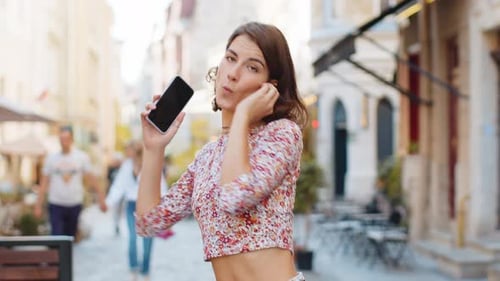 Happy Woman in Wireless Earphones Dancing Listening Music in Smartphone Dancing Walking City Street