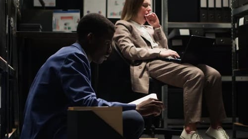 Colleagues Work Late in Dim Archive Room