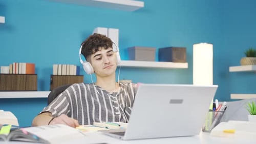 Young Man Listens to Music While Working