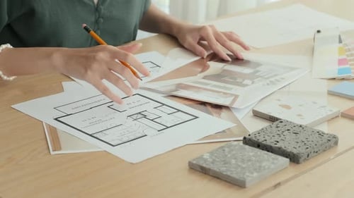 Innenarchitektin macht sich Notizen zum Grundriss der Wohnung