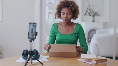 Woman filming herself opening a package