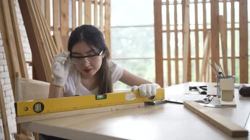 Carpenter is working at woodshop.