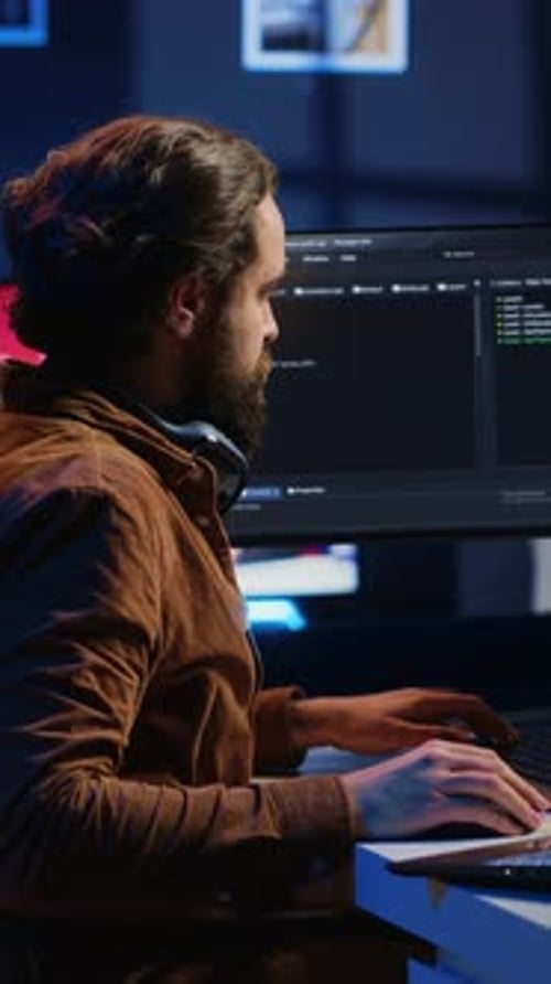 Software Technician Typing Code in Neon Lit Personal Office