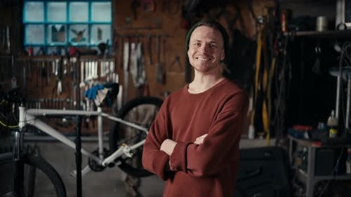 Young Adult Smiling with Folded Arms In Workshop