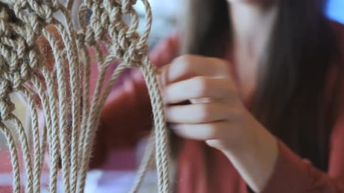 close-up woman making knots for macrame
