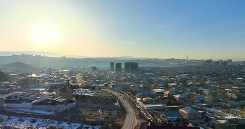 Luftbild: Ein verschneites Stadtbild von Eriwan, Armenien, mit ein paar Häusern und ein paar Autos
