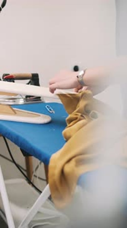Cutting Fabric on Blue Ironing Board with Tailor's Tools