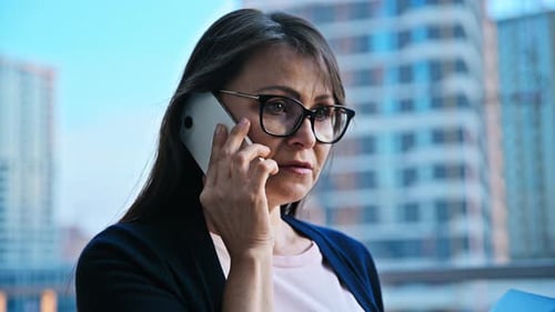 Mature Business Woman Talking on Mobile Phone Modern City Background