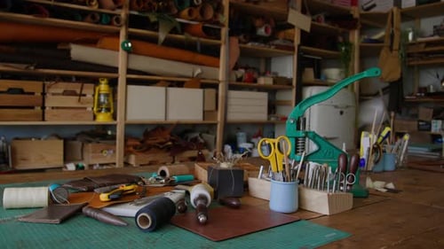 Werkbank aus Holz, vollgestopft mit einer Sammlung von Lederwerkzeugen in der Handwerkswerkstatt
