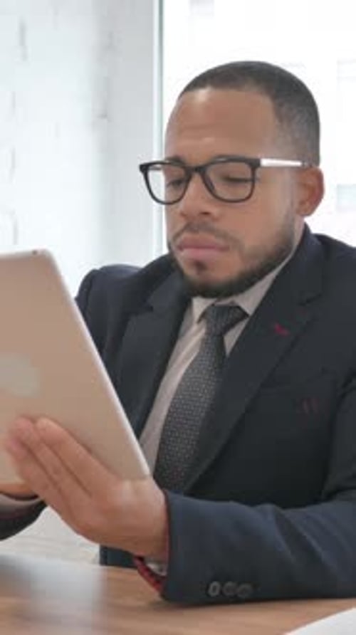 Mixed Race Businessman Using Digital Tablet in Office, vertical video