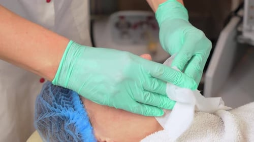 Aesthetician Wipes Woman's Face in Spa Setting