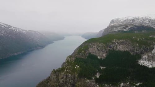 Incredible view of a mountain range covered in mist and fog in Scandinavia