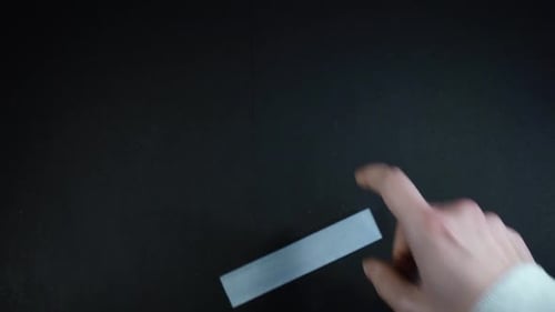 Hand Placing a Gray Sheet Next to Plant Material