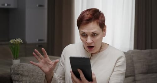 Woman Receives Good News on Tablet, Celebrates
