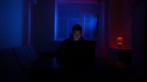 Adult Using Laptop in Blue and Red Light