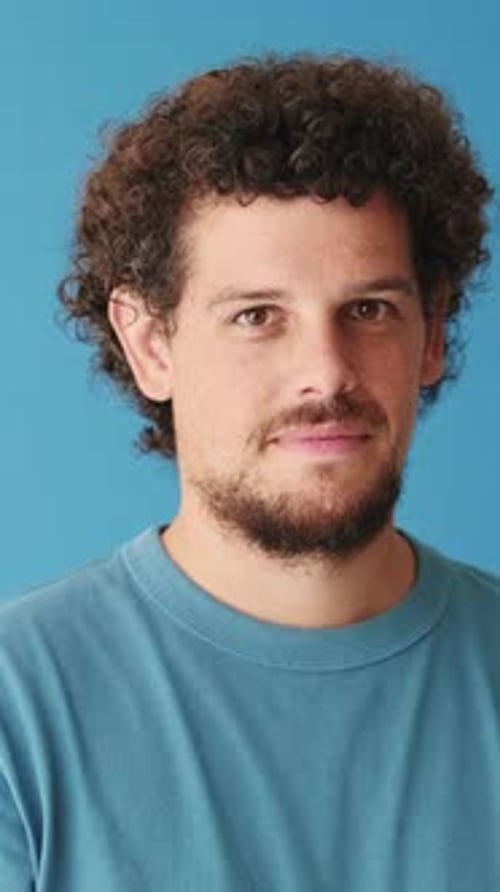 Close up, happy man showing ok gesture isolated on blue background in studio