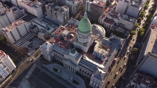 Aerial birds eye view of National Congress in Buenos Aires and driving cars on road during sunset -