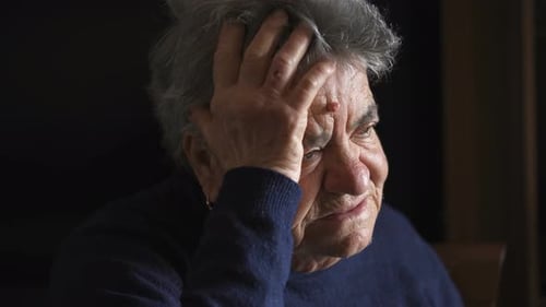 Senior Person Holding Head in Close Up Shot