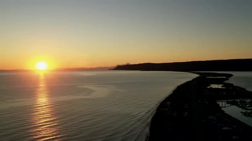 beautiful timelapse of the sunset over the flat rippling ocean and the shores with its beautiful ora