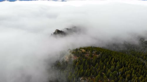 Misty Low Fog And Clouds Over Rocky Mountain Alpine Woodland Hill Peaks. 4K Drone.
