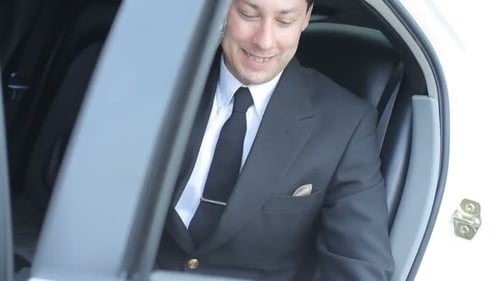 Man in Suit Talking on Phone in Car