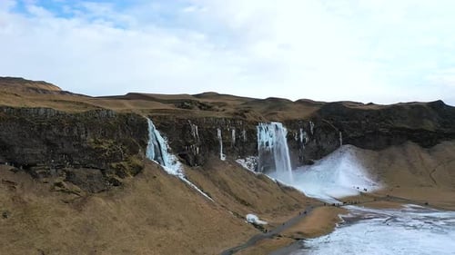 Majestic Seljalandsfoss waterfall in Iceland, showcasing its icy cascades against a winter backdrop.