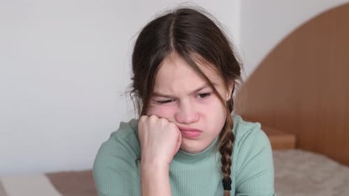 Closeup Sad Preteen Girl Sitting on Bed at Home Depressed Child Having Bad Mood