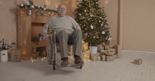 Elderly Man in Wheelchair by Christmas Tree