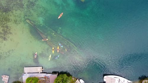 Group of people paddle boarding, canoeing over shipwreck Georgian bay