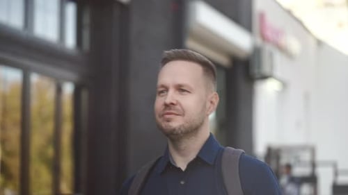 A Young Man in a Good Mood Walks Along a City Street Portrait of a City Guy in a Shirt and with a