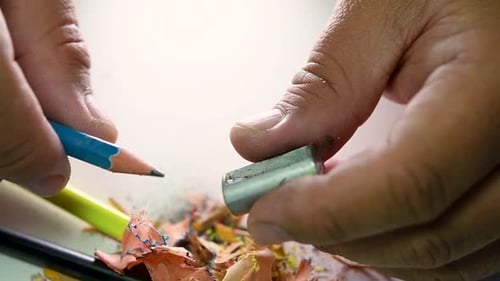 Footage of hands slowly sharpening a pencil and some coloured pencils with a Wedge Pencil Sharpener.
