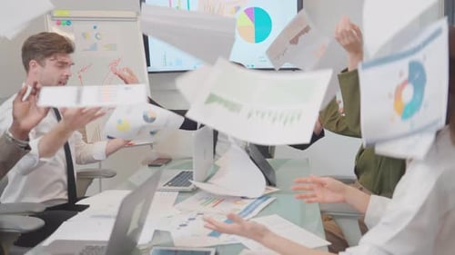 Side view of manager and his business team celebrate the success of the project by throwing paper