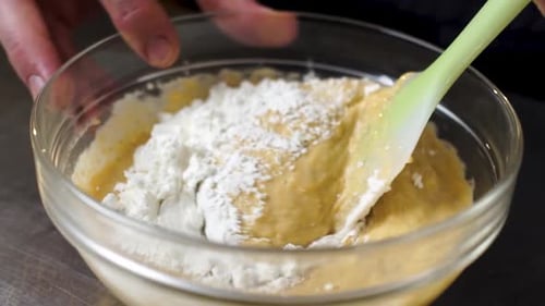 Stirring pudding in a glass bowl in slow motion. A detailed view of the production of a sweet desser