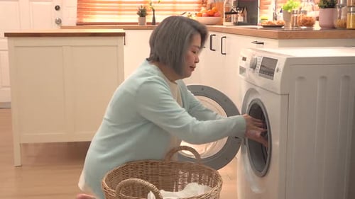 Woman Loads Clothes into Washing Machine