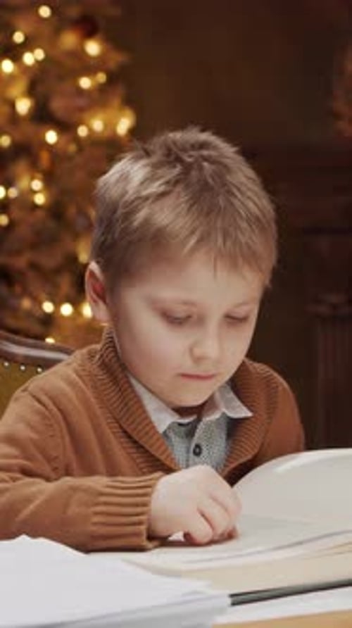 Young Boy Sits at the Table Engrossed in a Magical Book The Cozy Home Interior Features a