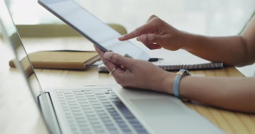 4k video footage of an unrecognizable businessperson using a laptop and digital tablet at work
