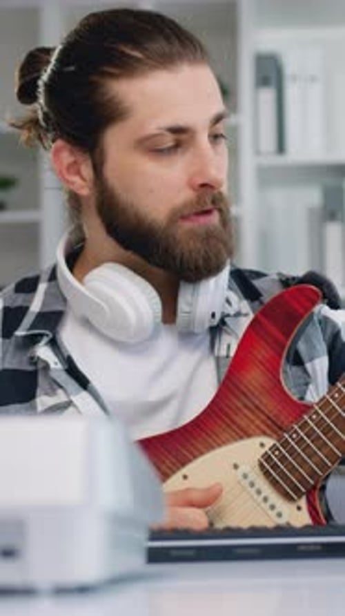 Bearded Man Playing Electric Guitar at Home