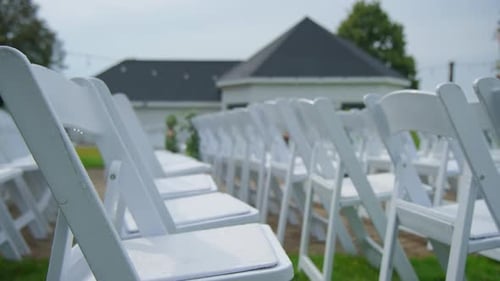 Wedding Ceremony Setup with Rows of White Chairs