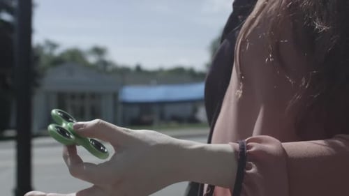 Une femme rousse caucasienne virevolte en utilisant un fidget spinner, un jouet à tirer avec stabilisateur