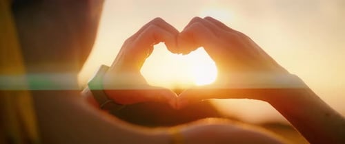 Silhouette of Woman Hands with Heart Shape Sign on Sunrise Sky Close Up Love Romantic Positive