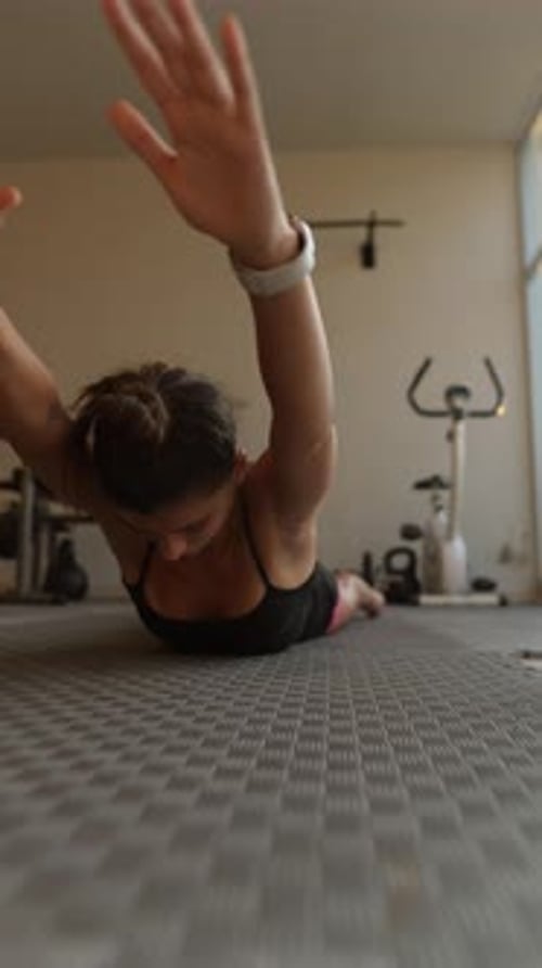 Woman Working Out Arms on Floor in Gym