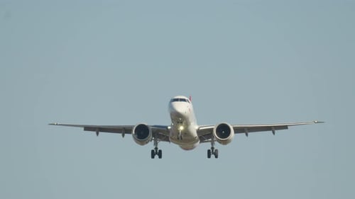 Passenger airplane lands on airport runway during sunset approach