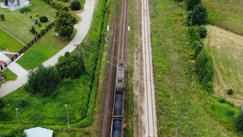 Freight Train Traversing Green Rural Landscape Aerial View